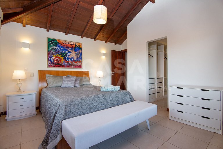 Casa com quatro suítes, sala de tv, piscina e churrasqueira.